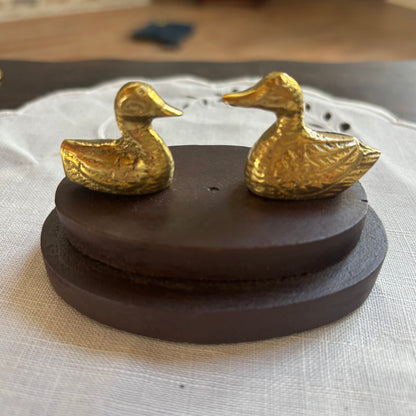 Small Brass Ducks on Wood Surface