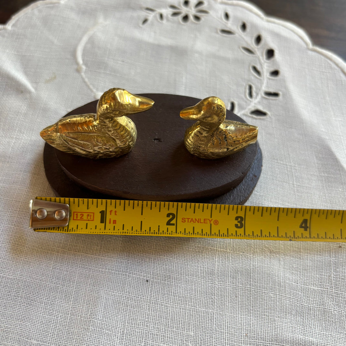 Small Brass Ducks on Wood Surface